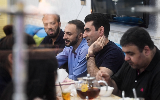 在义乌居住了近17年的阿富汗东说念主阿兹兹（左二）在义乌的甜品店里与客商伙伴聊天。新华社